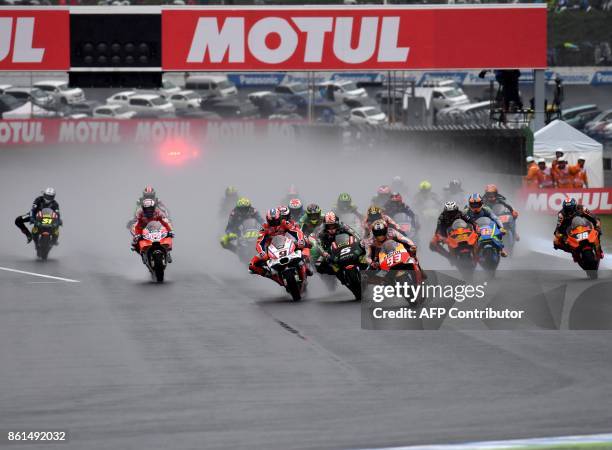 Honda rider Marc Marquez of Spain leads the pack entering the first turn right after the start of the MotoGP Japanese Grand Prix at Twin Ring Motegi...