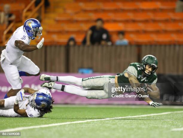 Keelan Ewaliko of the Hawaii Rainbow Warriors is taken down short of the end zone after being tripped up by Andre Chachere of the San Jose State...