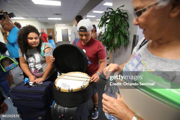 From left, Samiliz Ruiz Collazo looks as his brother Mizraim Ruiz Collazo shows the drum he brought to his grandmother Beatriz Rodriguez, who went to...