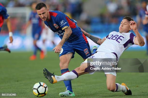 Roy O'Donovan of the Jets contests the ball against Scott Neville of Perth Glory during the round two A-League match between the Newcastle Jets and...