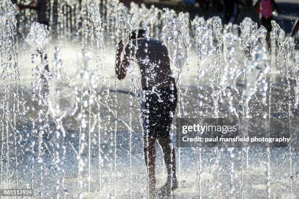 boy playing in shower fountain - outdoor water fountain stock pictures, royalty-free photos & images