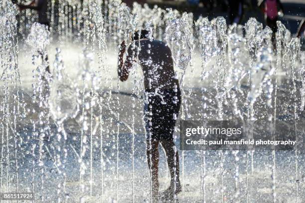 boy playing in shower fountain - heatwave 個照片及圖片檔