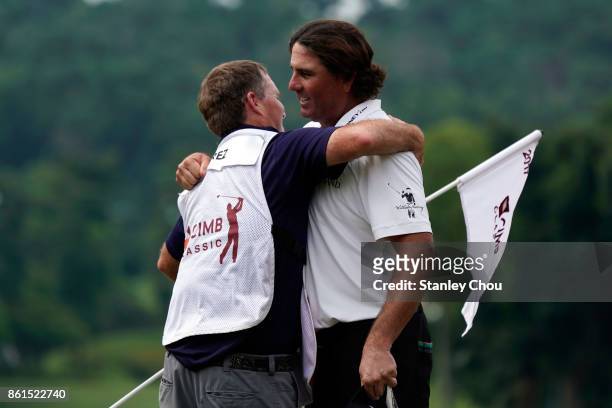 Pat Perez of the United States celebrates with his caddie on the 18th hole after the final round of the 2017 CIMB Classic at TPC Kuala Lumpur on...