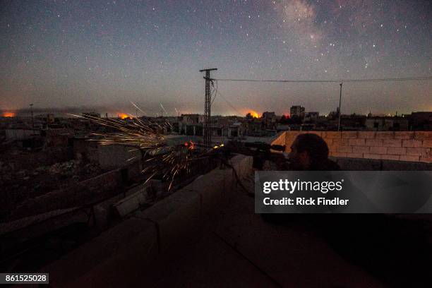 British volunteer fighter 'Macer Gifford' shoots his sniper rifle at ISIS positions in the late hours of the evening on August 18, 2017 in Raqqa Five...