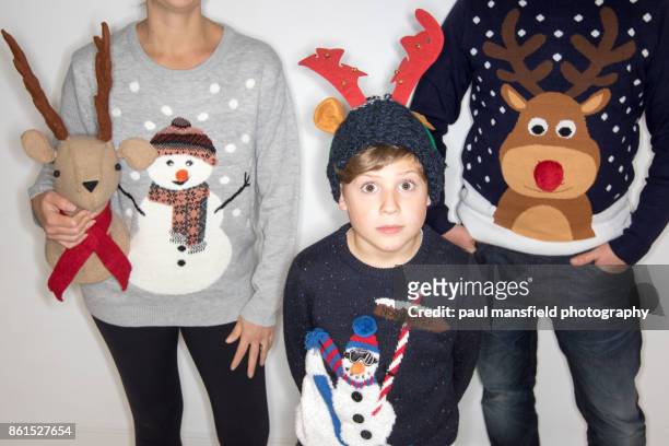 quirky portrait of family wearing christmas jumpers - weihnachtspullover stock-fotos und bilder