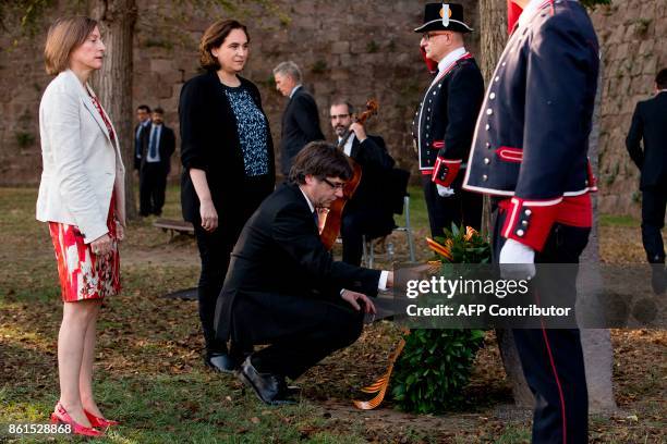 Catalan regional government president Carles Puigdemont lays a wreath next to Catalan parliament president Carme Forcadell and Barcelona mayor Ada...