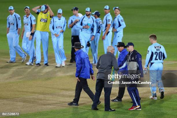 Peter Handscomb of Victoria shakes match referees Daryl Harper's hand during the JLT One Day Cup match between New South Wales and Victoria at North...