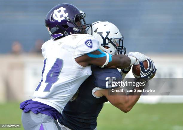 Yale Bulldogs defensive back Hayden Carlson gets over Holy Cross Crusaders wide receiver Andre Harton and intercepts the ball during the game between...