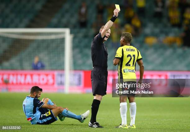 Referee Kurt Ams gives Roy Krishna of Wellington a yellow card during the round two A-League match between Sydney FC and the Wellington Phoenix at...