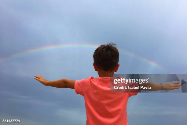 boy (5-6) in front of rainbow - rainbow kids stock-fotos und bilder