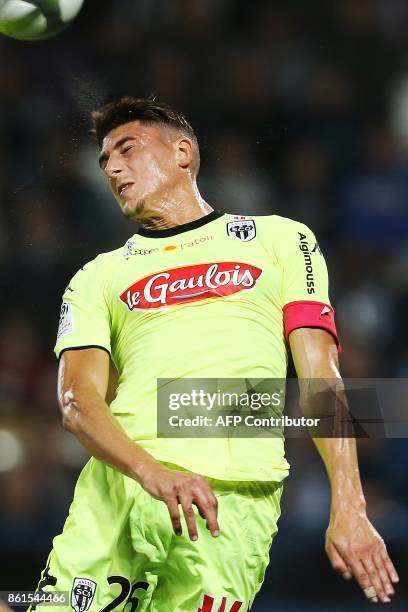 Angers's Algerian defender Mehdi Tahrat heads the ball during the French L1 football match between Caen and Angers on October 14 at the Michel...