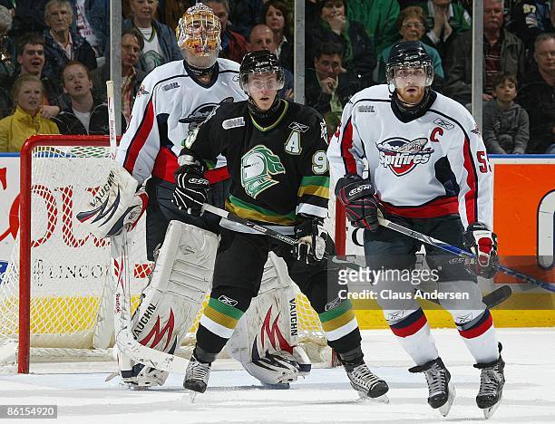 Justin Taylor of the London Knights looks for a shot to come in while standing between Andrew Engelage and Harry Young of the Windsor Spitfires in...