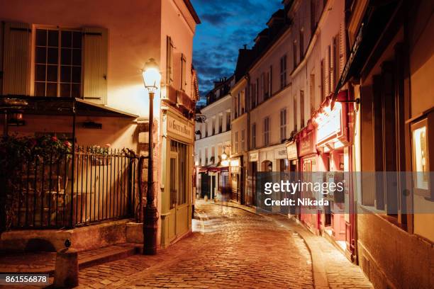 beleuchtete straßen von montmartre viertel, straße in paris bei nacht - french cafe stock-fotos und bilder