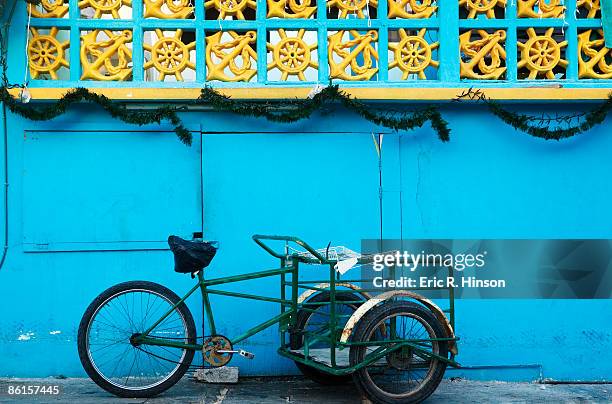 blue house with tricycle - insel mujeres stock-fotos und bilder