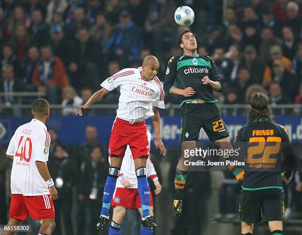 Alex Silva of Hamburg and Hugo Almeida of Bremen battle for the ball during the DFB Cup Semi Final match between Hamburger SV and SV Werder Bremen at...