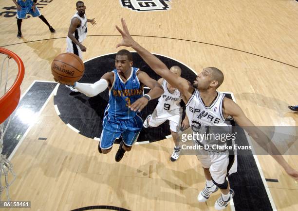 Chris Paul of the New Orleans Hornets drives to the basket for a layup against Tony Parker and Tim Duncan of the San Antonio Spurs during the game at...