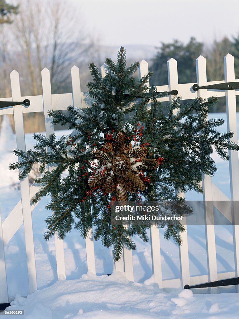 Holiday garland on white picket fence