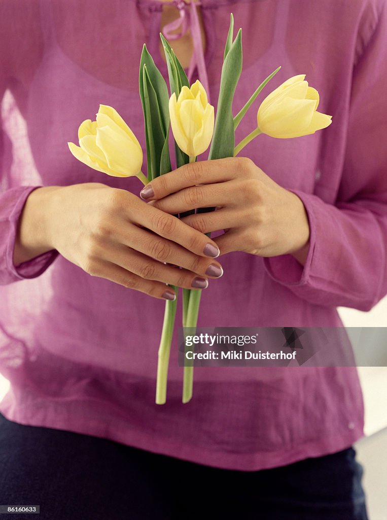 Woman holding yellow tulips