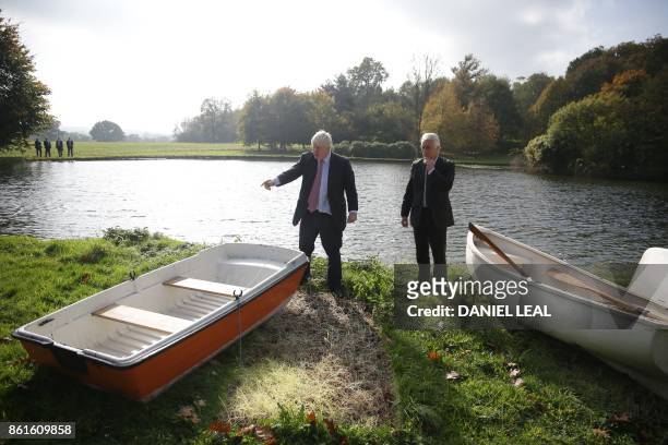Britain's Foreign Secretary Boris Johnson and Slovenia's State Secretary at the Ministry of Foreign Affairs Andrej Logar select a boat to put out on...