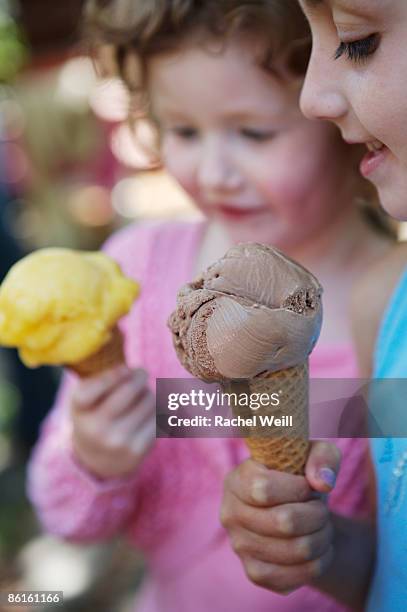 girls holding chocolate ice cream and orange sorbet cones - orange sorbet stock pictures, royalty-free photos & images