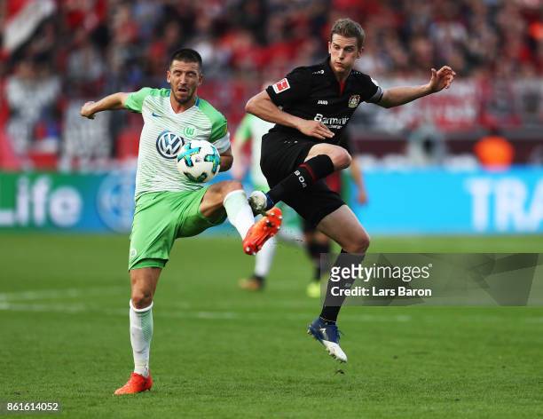 Ignacio Camacho of VfL Wolfsburg is challenged by Lars Bender of Bayer Leverkusen and Lucas Alario of Bayer Leverkusen during the Bundesliga match...