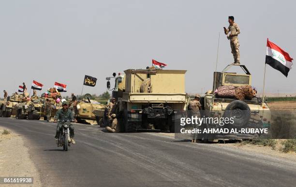 Iraqi forces rest on the road as they drive towards Kurdish peshmerga positions on October 15 on the southern outskirts of Kirkuk. - The presidents...