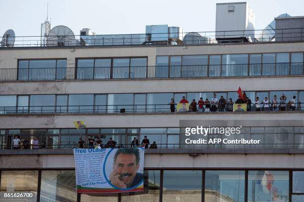 Kurdish people wave flags and banners picturing jailed Kurdish leader Abdullah Ocalan as they take part in a demonstration on the balconies, after...