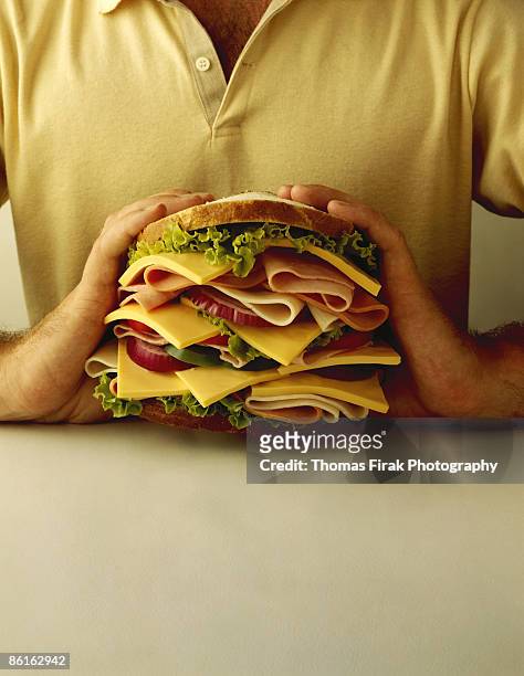 man holding large sandwich -  firak stock pictures, royalty-free photos & images