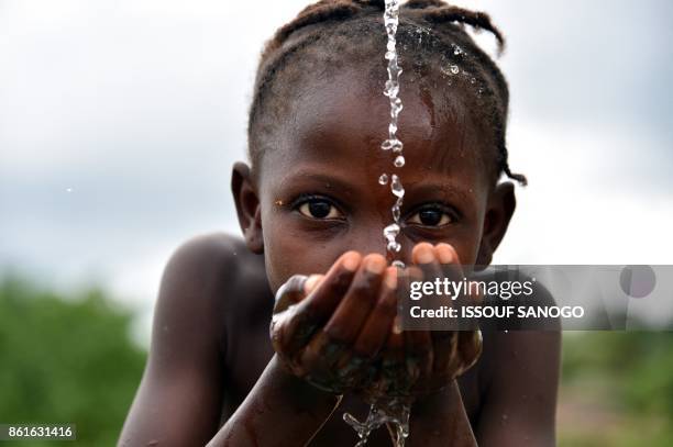 Picture taken on October 12, 2017 shows a student drinking water at the fountain of the Public school of Freeman Reserve in the Todee District, about...