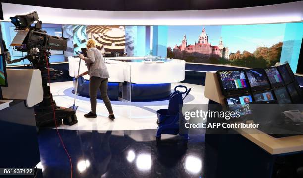 Woman cleans the floor of a public television studio in Hanover on October 15 ahead of the television debate on the election results of the...