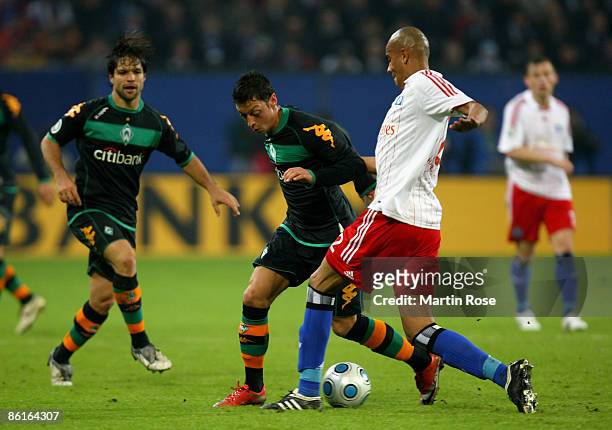 Alex Silva of Hamburg and Mesut Oezil of Bremen battle for the ball during the DFB Cup Semi Final match between Hamburger SV and SV Werder Bremen at...