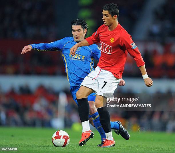 Manchester United's Portugese midfielder Cristiano Ronaldo vies with Portsmouth's Scottish midfielder Richard Hughes during the English Premiership...