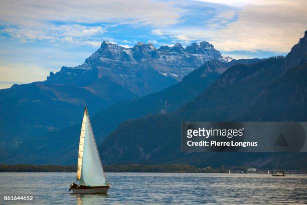 unmarked sailboats cruising at sunset on lake geneva in late summer with the famous "dents du midi" mountain in backdrop, switzerland - lake geneva switzerland stock pictures, royalty-free photos & images