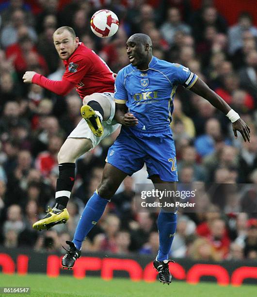 Sol Campbell of Portsmouth competes against Wayne Rooney of Manchester United during the Barclays Premier League match between Manchester United and...