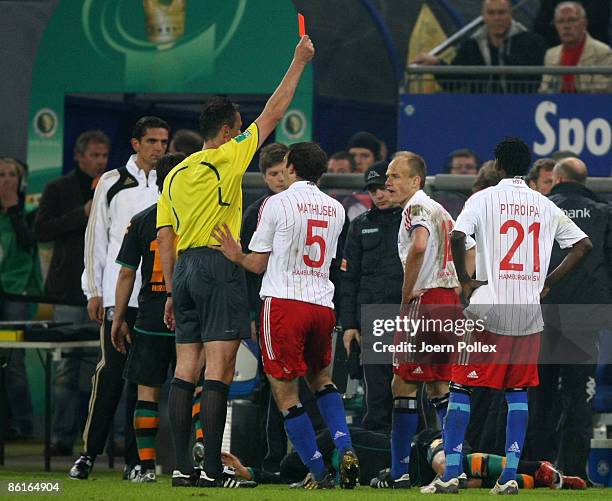 Referee Knut Kircher shows David Jarolim of Hamburg the red card during the DFB Cup Semi Final match between Hamburger SV and SV Werder Bremen at the...