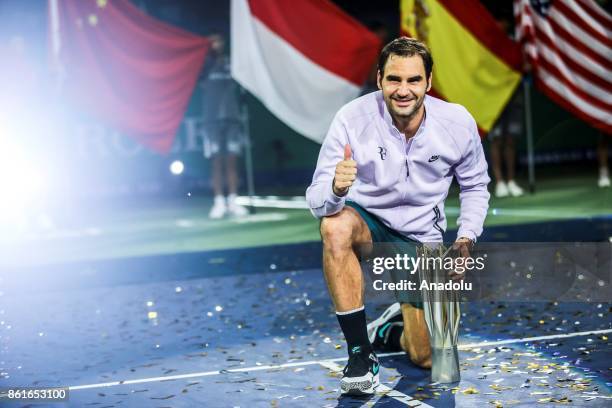 Roger Federer of Switzerland poses with the trophy during the award ceremony after winning his Men's singles final match against Rafael Nadal of...