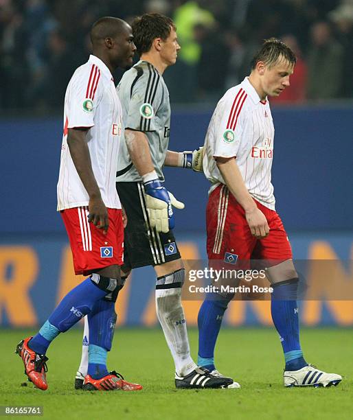 Guy Demel, Frank Rost and Ivica Olic of Hamburg walk off dejected after the DFB Cup Semi Final match between Hamburger SV and SV Werder Bremen at the...