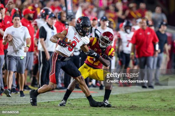 Wide receiver Darren Carrington II of the Utah Utes catches the ball as he is tackled by cornerback Ajene Harris of the USC Trojans in a game between...