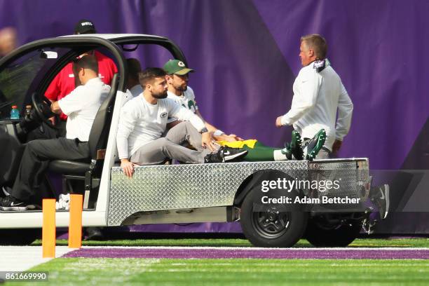 Aaron Rodgers of the Green Bay Packers rides a cart into the locker room after being injured during the first quarter of the game against the...