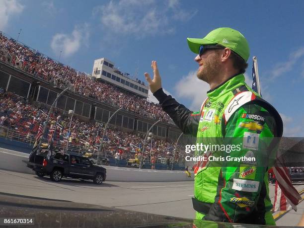 Dale Earnhardt Jr., driver of the Mountain Dew Chevrolet, waves to the crowd on his driver introduction lap prior to the Monster Energy NASCAR Cup...