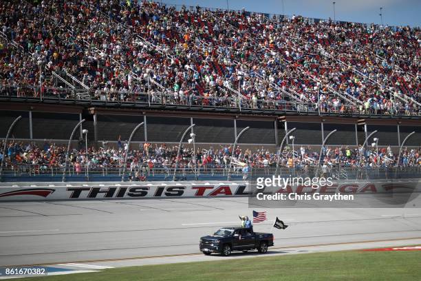 Dale Earnhardt Jr., driver of the Mountain Dew Chevrolet, waves to the crowd on his driver introduction lap prior to the Monster Energy NASCAR Cup...