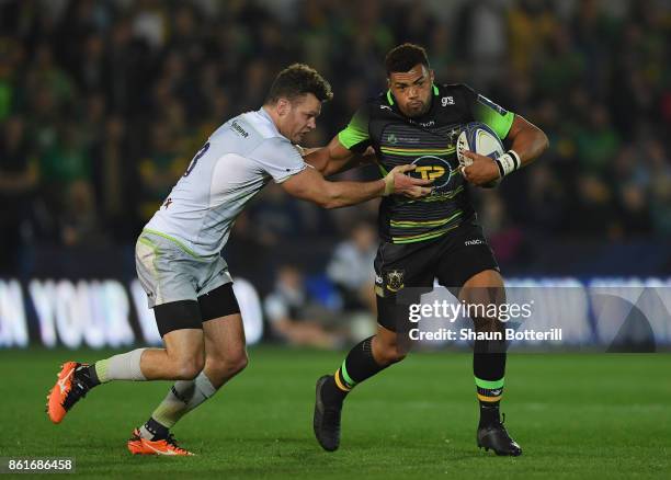 Luther Burrell of Northampton Saints is tackled by Duncan Taylor of Saracens during the European Rugby Champions Cup match between Northampton Saints...