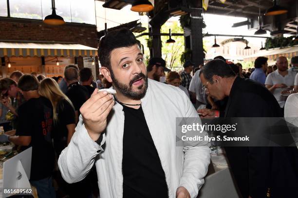 Host Adam Richman poses with a dish during Oyster Bash presented by Barnegat Oyster Collective sponsored by Modelo hosted by Adam Richman at The...