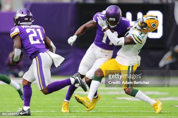 Jerick McKinnon of the Minnesota Vikings carries the ball past teammate Laquon Treadwell making an illegal hit against Lenzy Pipkins of the Green Bay...