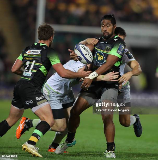 Ahsee Tuala of Northampton is tackled by Duncan Taylor and Alex Lozowski during the European Rugby Champions Cup match between Northampton Saints and...