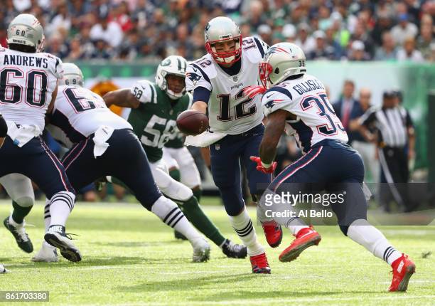 Quarterback Tom Brady of the New England Patriots hands off the ball to teammate running back Mike Gillislee against the New York Jets during the...