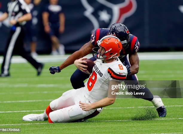 Kevin Hogan of the Cleveland Browns slides afer running with the ball as he takes a hit from Kurtis Drummond of the Houston Texans at NRG Stadium on...