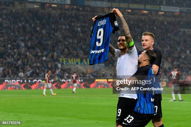 Inter Milan's Captain Argentinian forward Mauro Icardi shows his jersey to supporters as he celebrates with teammates at the end of the Italian Serie...