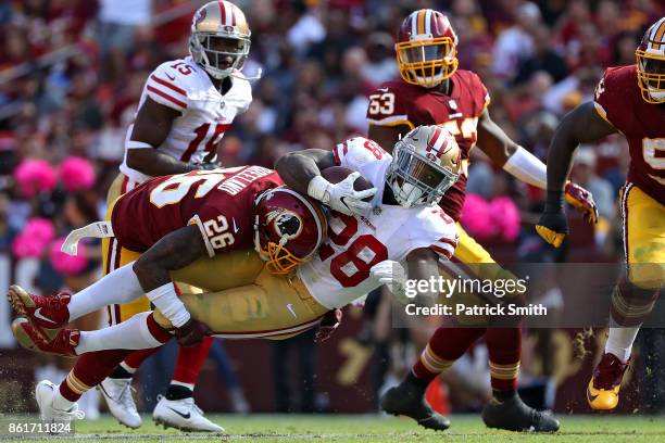 Running back Carlos Hyde of the San Francisco 49ers is tackled by cornerback Bashaud Breeland of the Washington Redskins during the during the third...