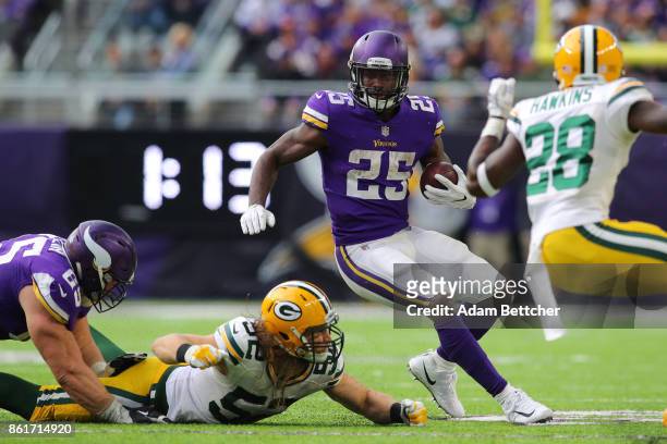 Latavius Murray of the Minnesota Vikings runs past Clay Matthews of the Green Bay Packers during the third quarter of the game on October 15, 2017 at...